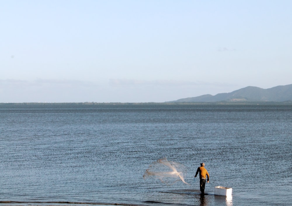 a man standing in the water with a fish net