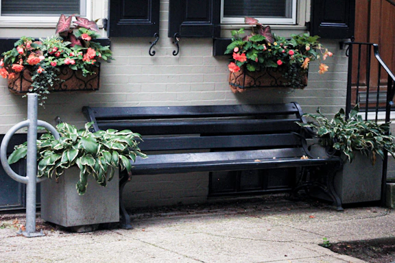 A welcoming outdoor space featuring planter boxes and cushions.