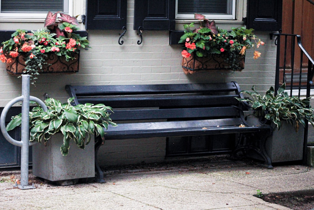 a black bench with two planters on top of it