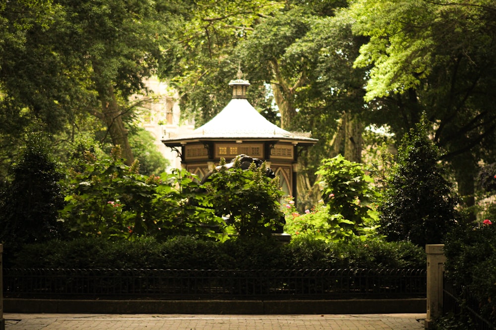 a wooden gazebo surrounded by lush green trees