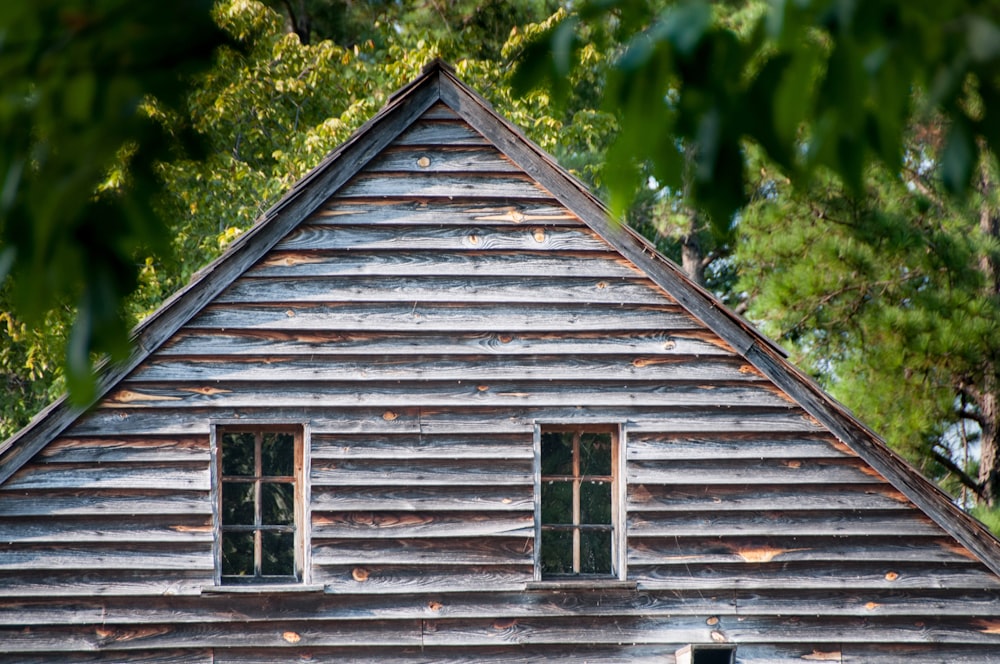 a wooden building with two windows and a roof