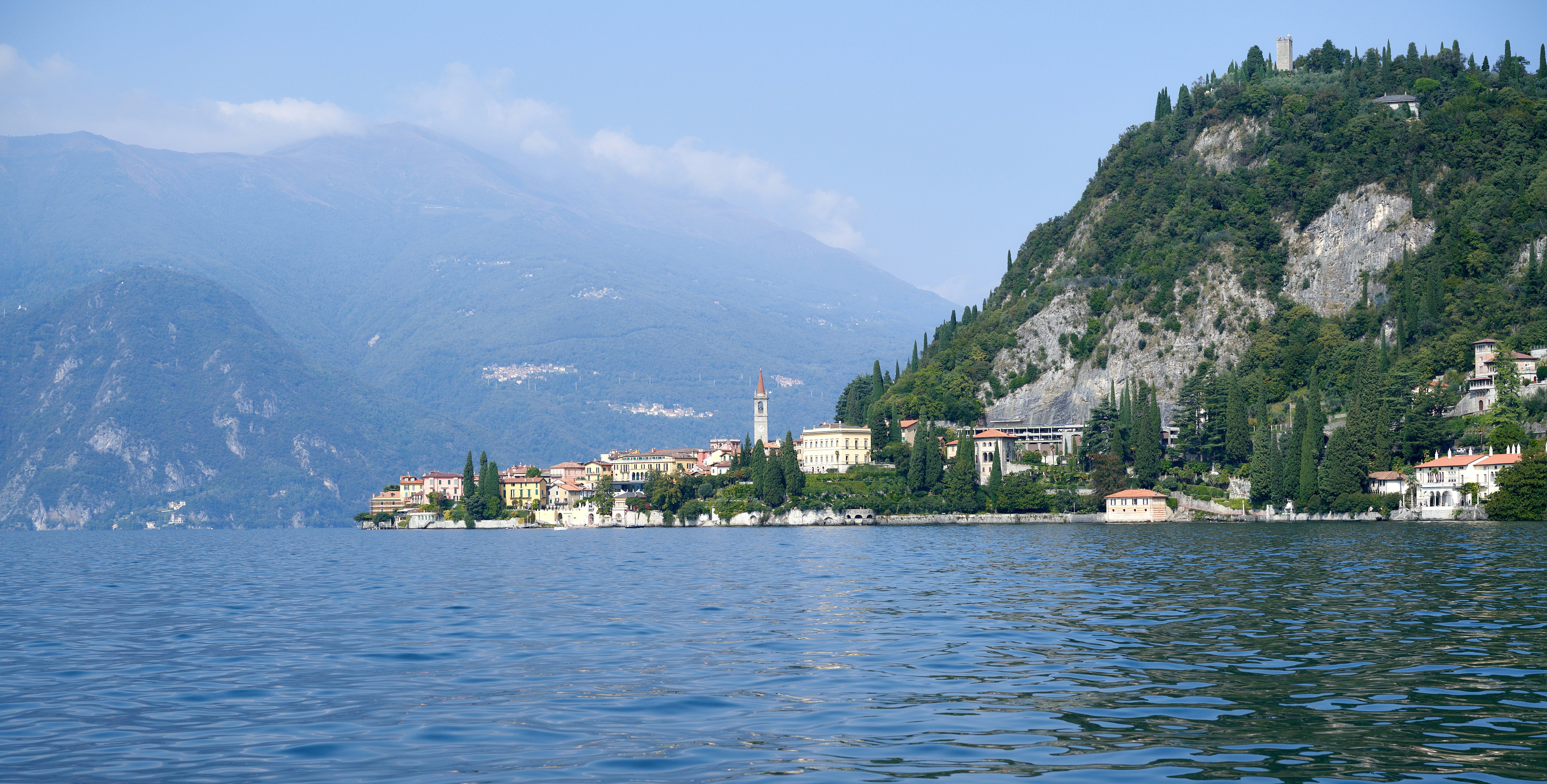 A view of a town on a lake with mountains in the background photo ...