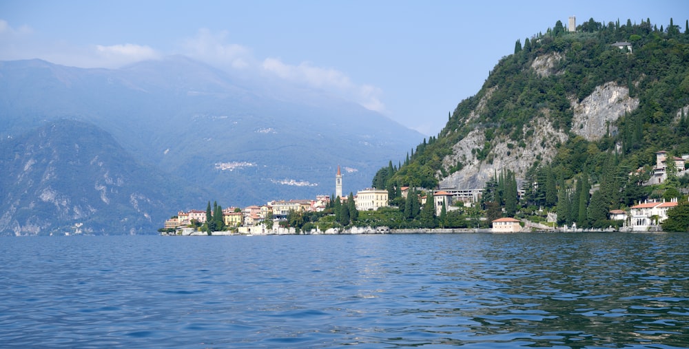 a view of a town on a lake with mountains in the background