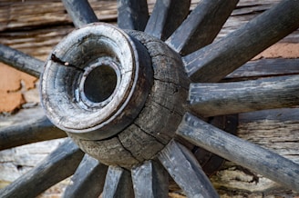 a close up of a wooden wheel on a building