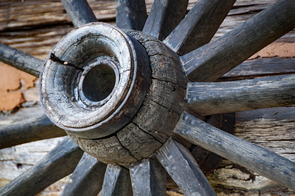 a close up of a wooden wheel on a building