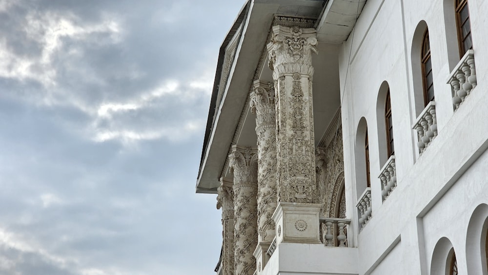 a tall white building with a clock on the side of it