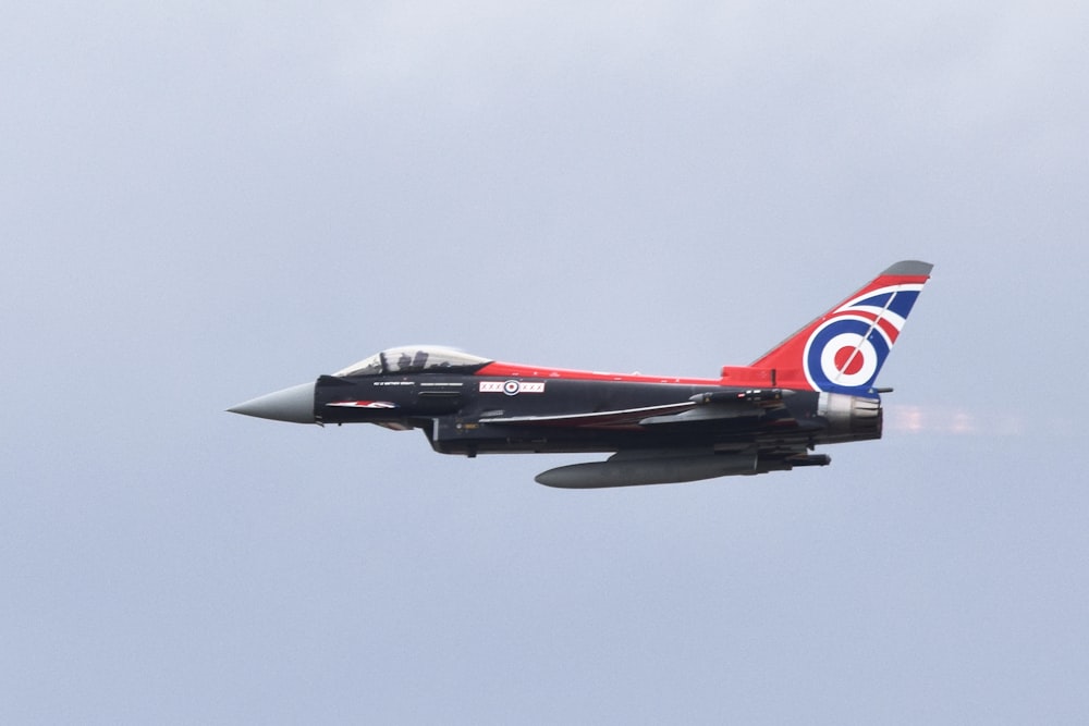 a fighter jet flying through a blue sky