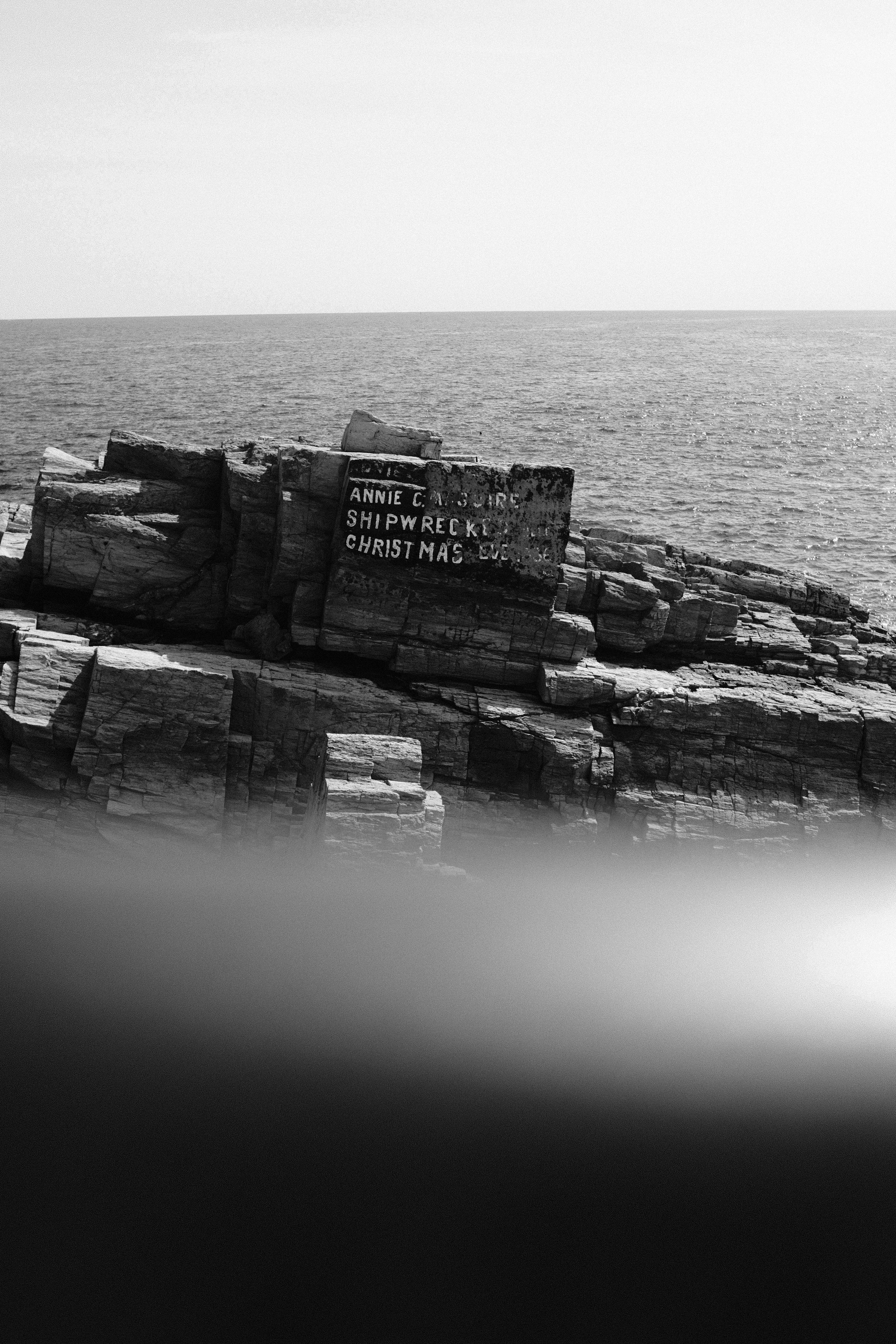 Una foto in bianco e nero di un segno su una roccia affiorante