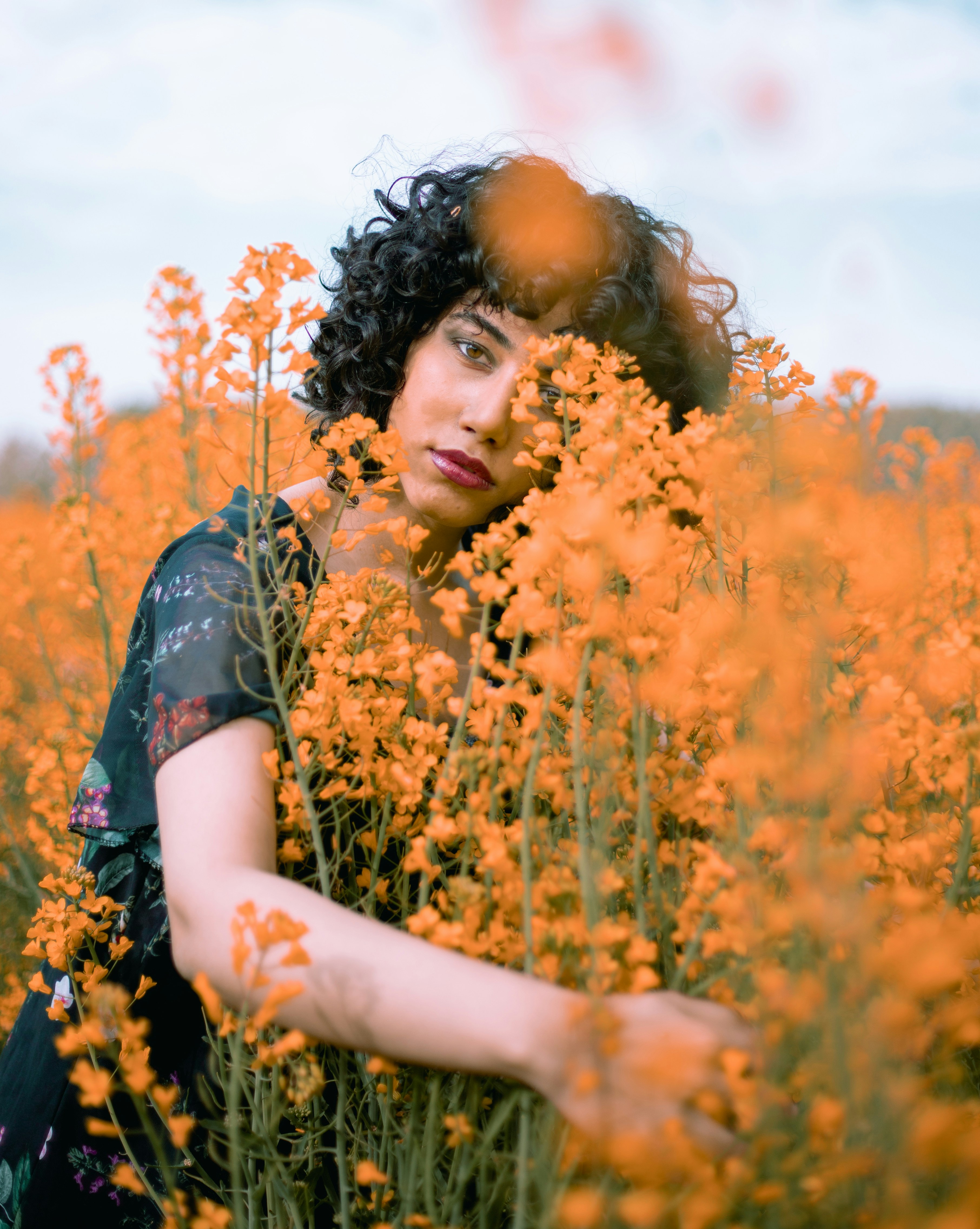 a woman standing in a field of yellow flowers