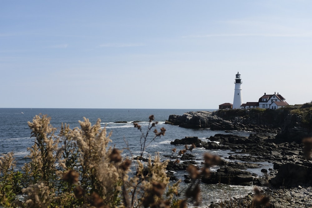 a light house sitting on top of a cliff next to the ocean