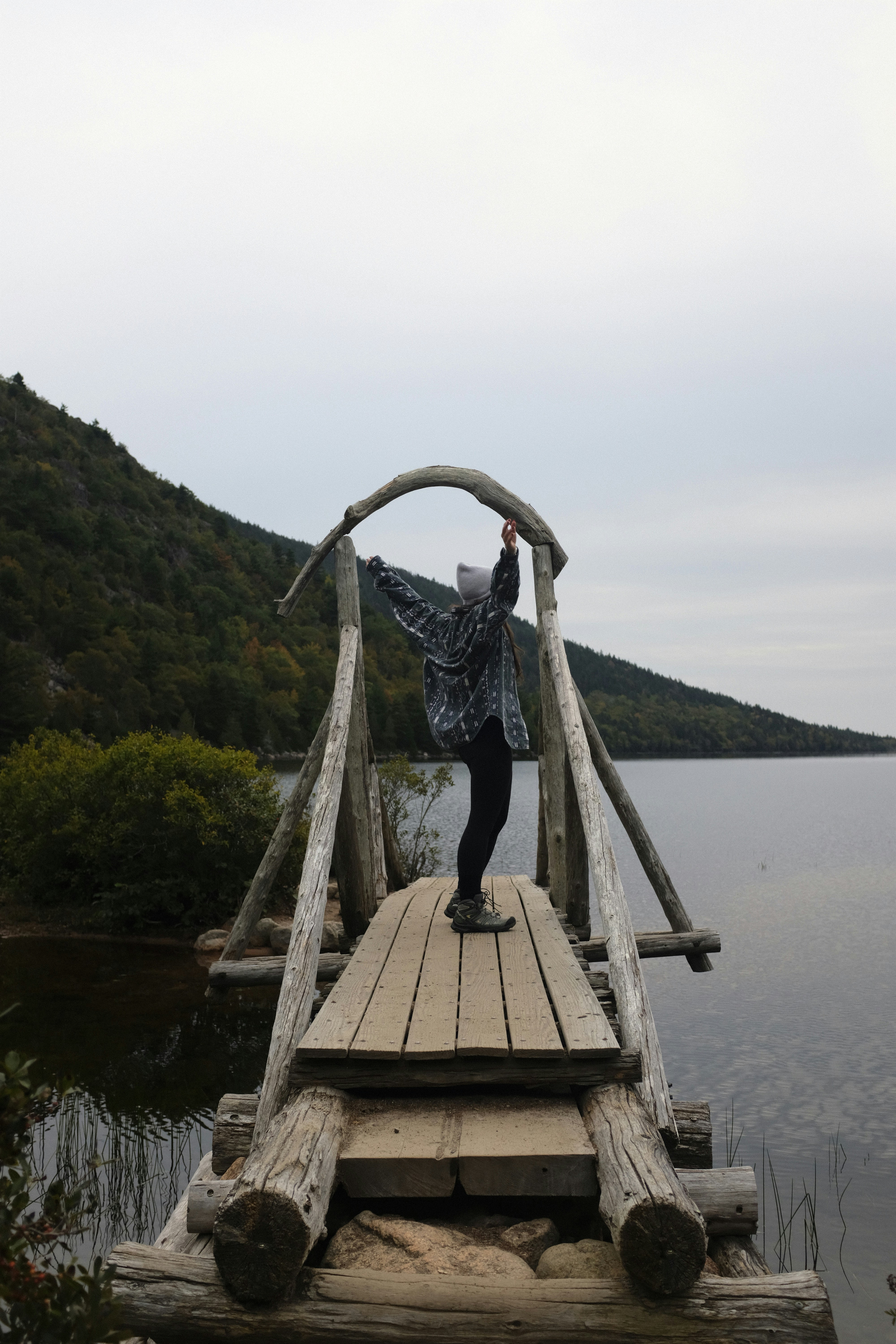 a person standing on a wooden bridge over a body of water