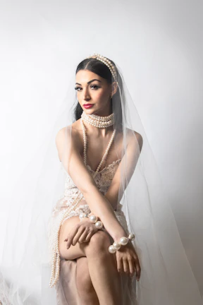 Elegant wedding attire featuring a delicate lace gown with pearl accessories.