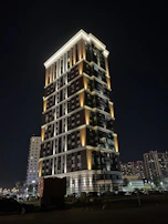 Evening exterior of the mixed-use development highlighting its elegant lighting and landscaping.