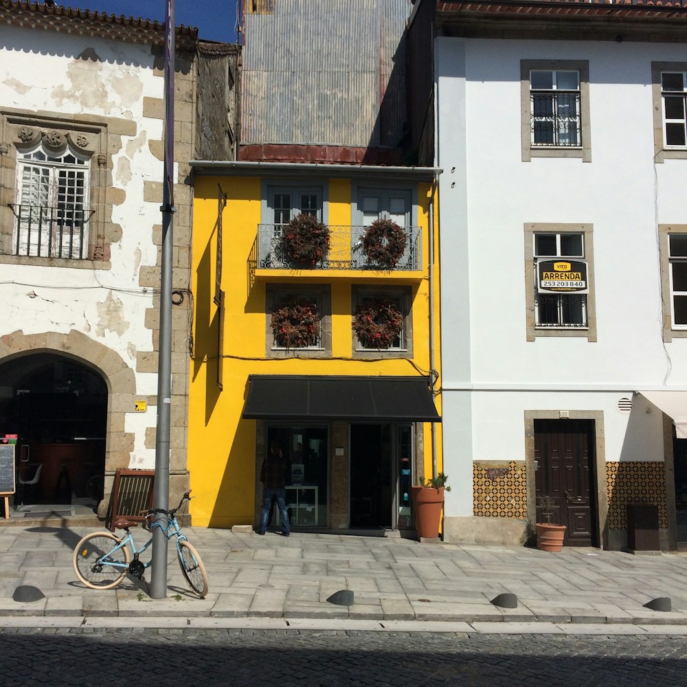 a bike parked in front of a yellow building