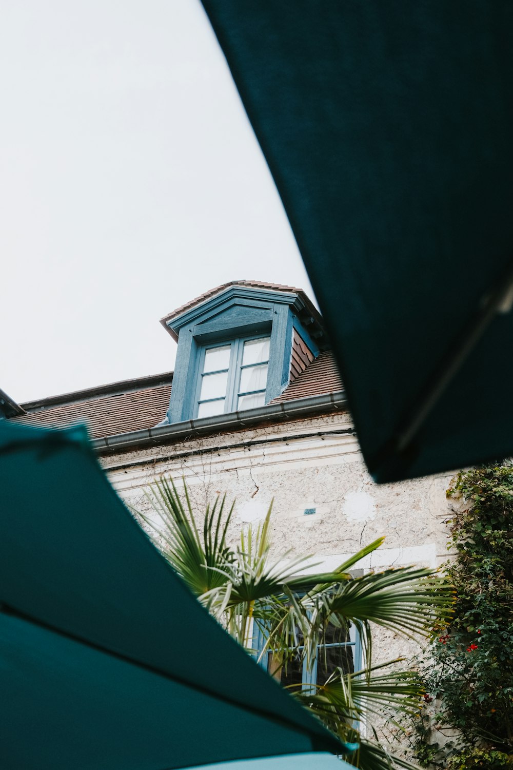 a building with a blue roof and a green umbrella