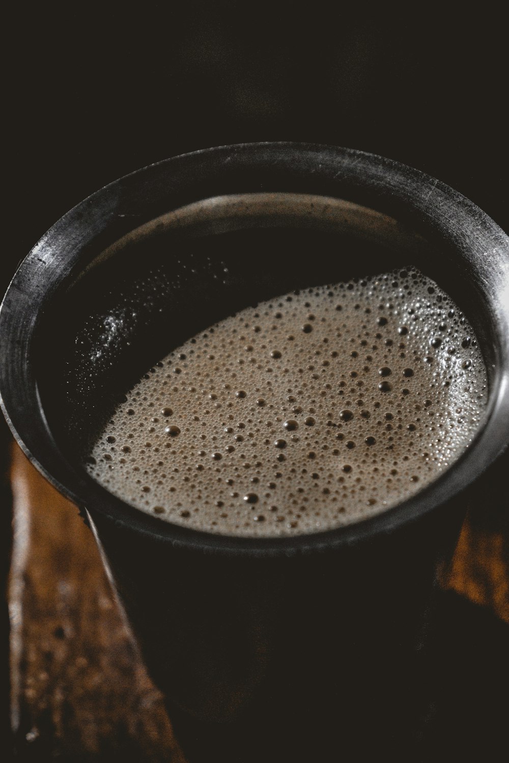 a cup of liquid sitting on top of a wooden table