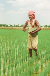 a man standing in a field holding a frisbee