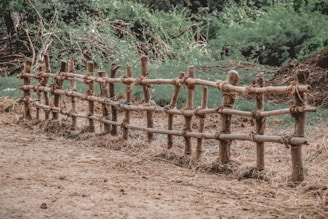 a fence made out of bamboo sticks in a field