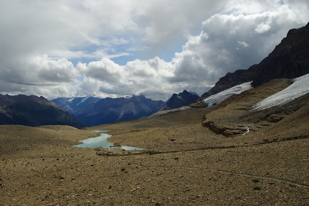 a view of a mountain range with a lake in the foreground