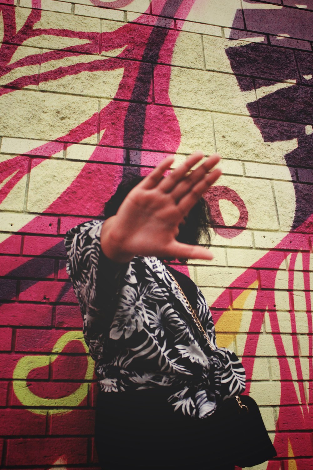 a woman standing in front of a brick wall