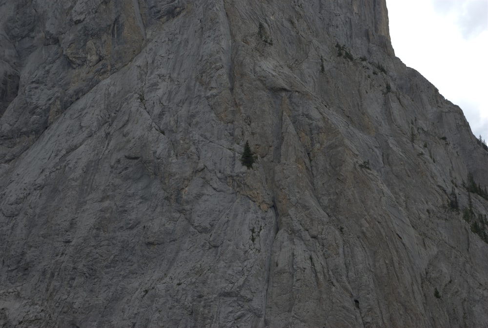 a large rock face with a sky background