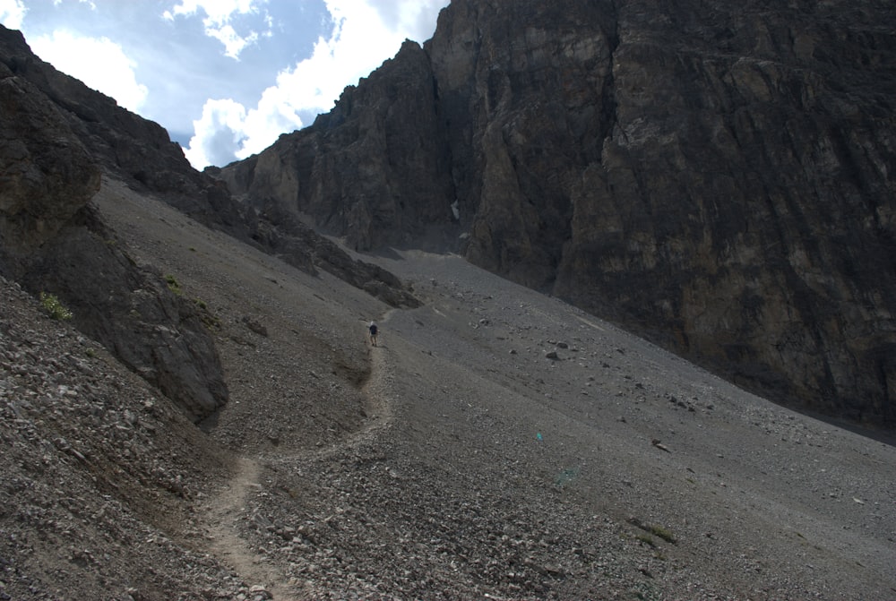 a person hiking up a rocky mountain side