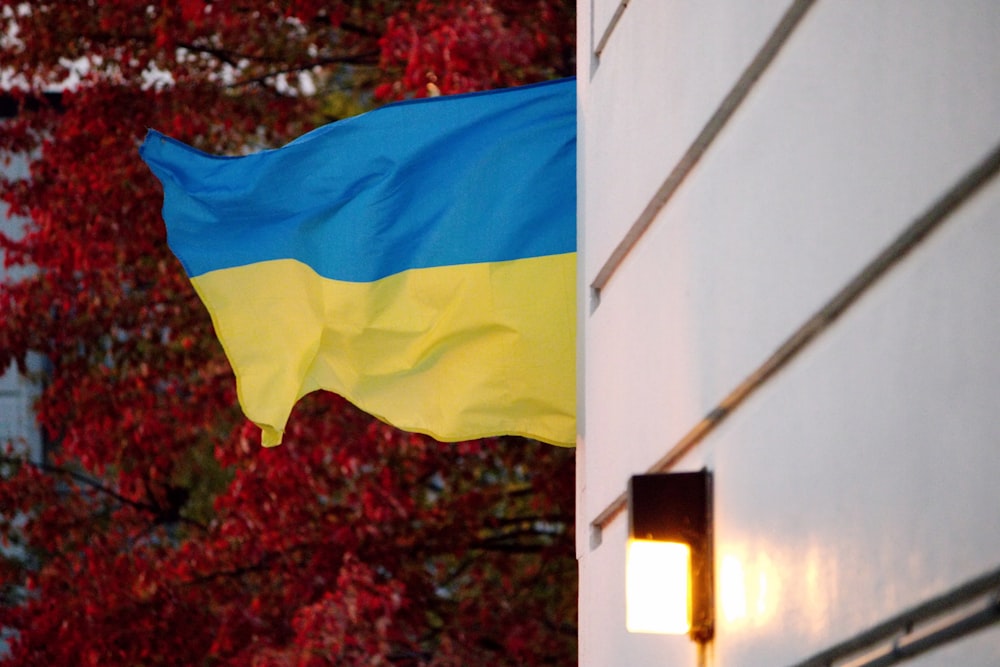 Uma bandeira da Ucrânia hasteada do lado de um edifício