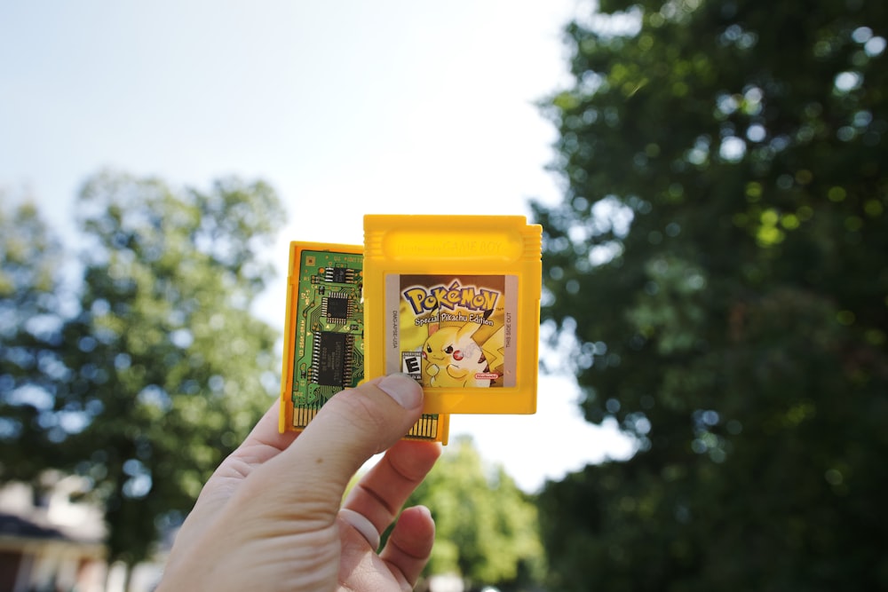 a person is holding a small yellow object