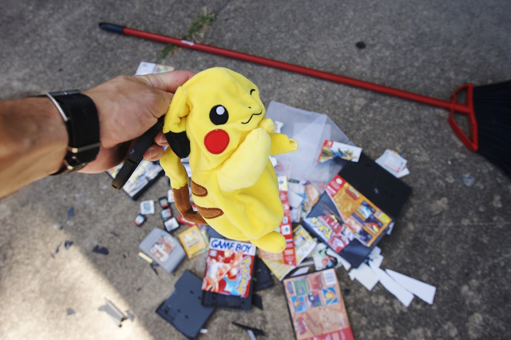 a person holding a stuffed pikachu in their hand