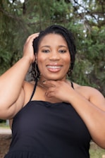 Portrait of Dr. Marina smiling warmly in a natural outdoor setting with greenery.