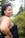 A smiling woman standing amidst lush green trees in the Amazon.