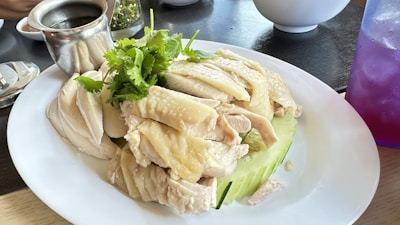 A vibrant plate featuring tender chicken slices, fresh cucumber, and a side of flavorful dipping sauce.