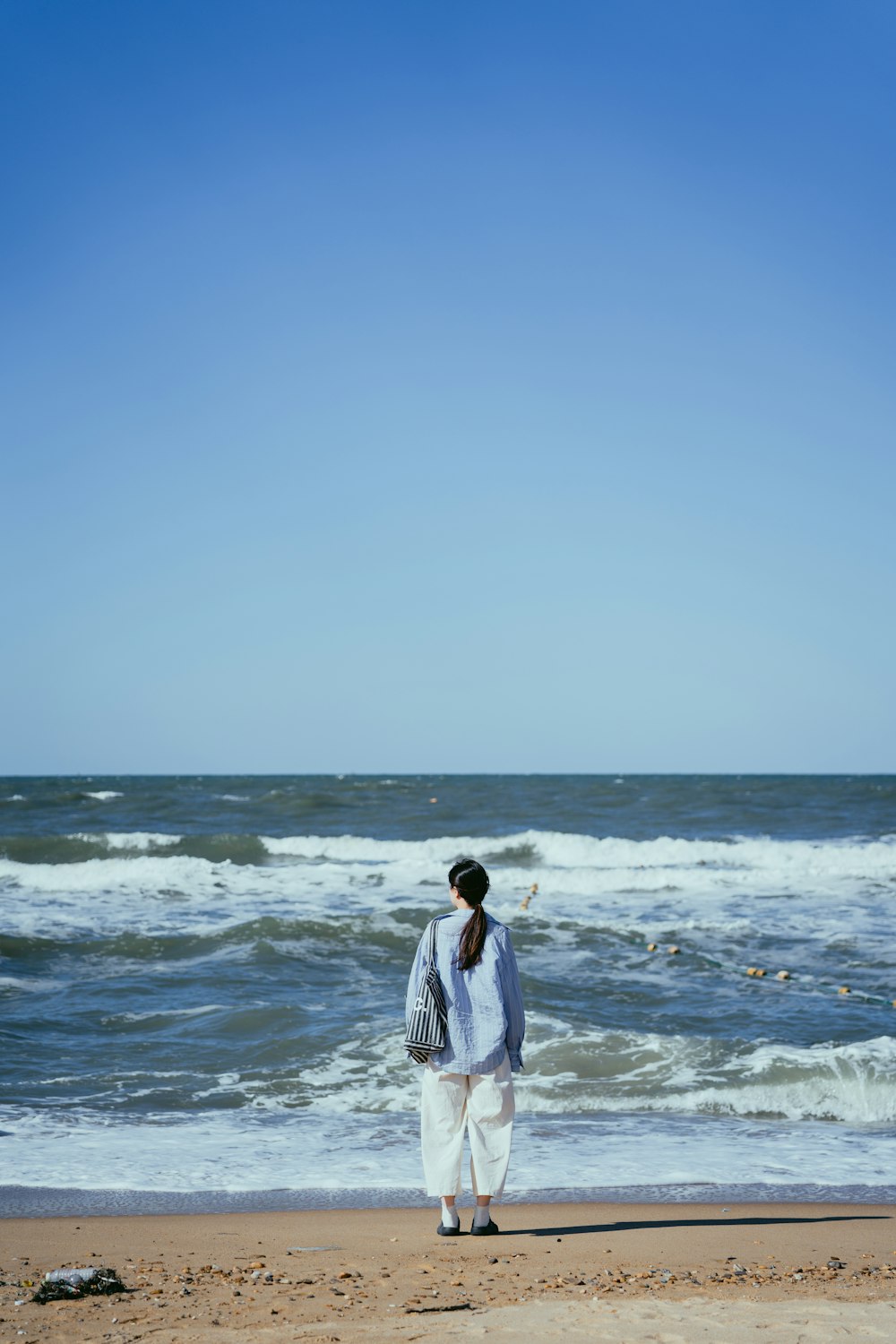 a man standing on a beach next to the ocean