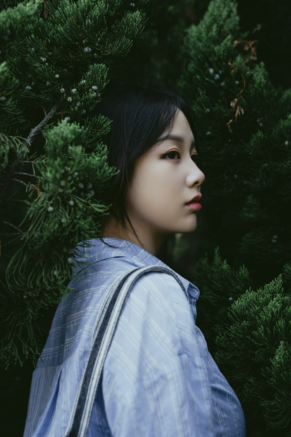 a woman standing in front of a tree