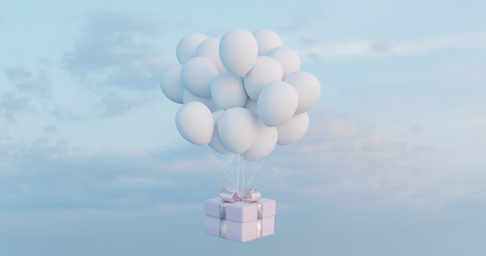 a gift box floating in the air with a bunch of balloons