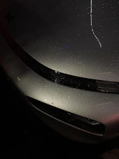 Glossy car surface reflecting light after ceramic coating application.