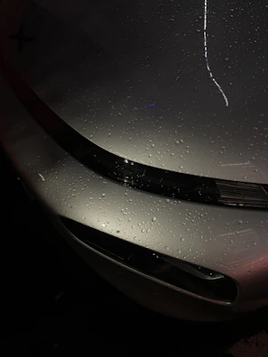 Hydrophobic ceramic coating beading perfectly formed on a sleek sports car hood.