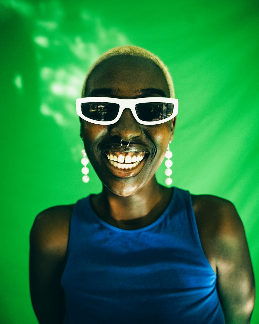 a woman wearing sunglasses and a blue tank top