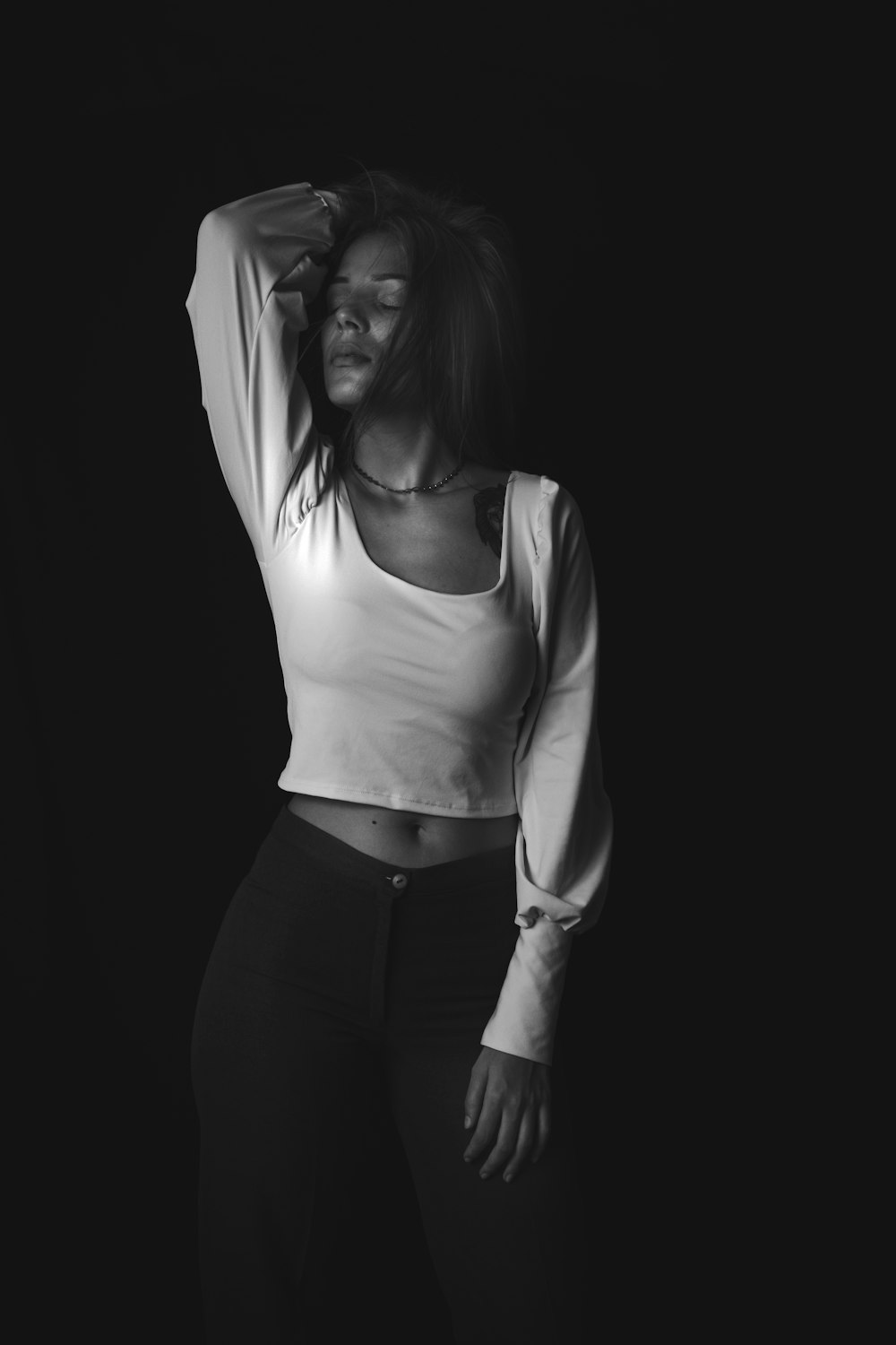 a black and white photo of a woman in a crop top