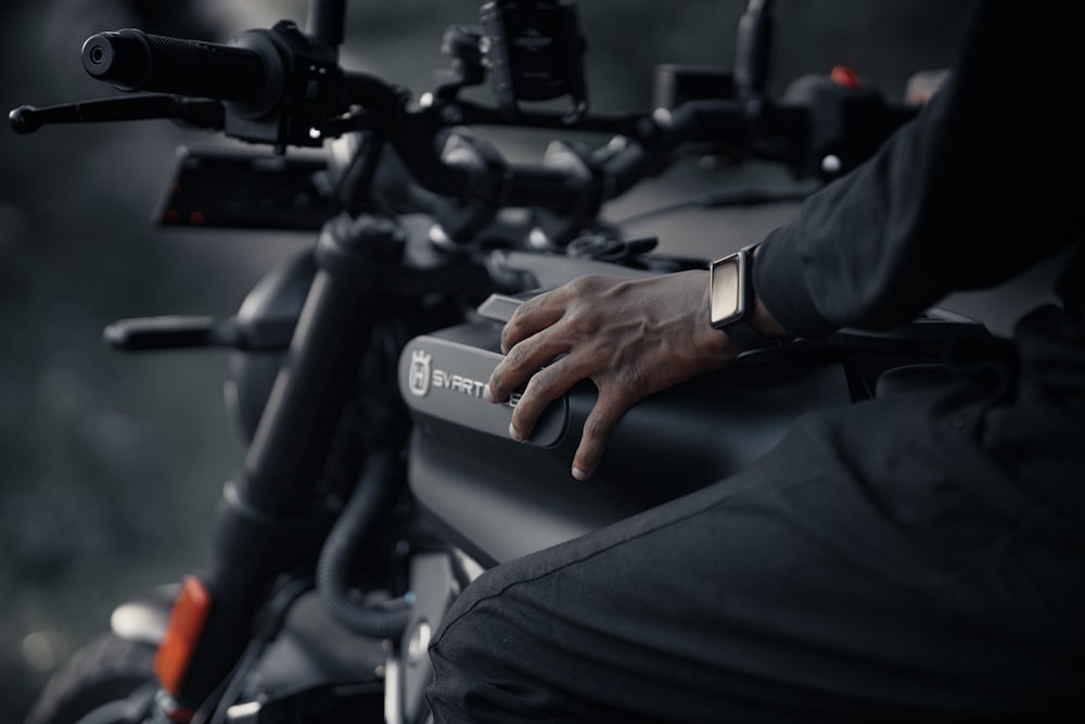 a person's hand resting on the handlebars of a motorcycle