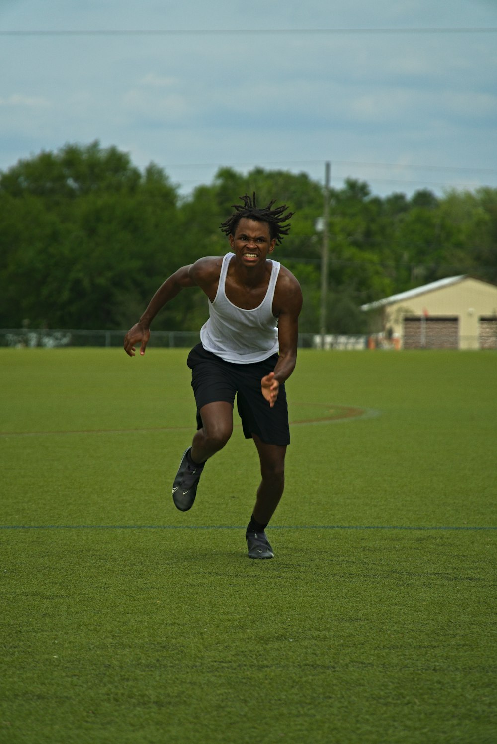 a man running across a field with a frisbee