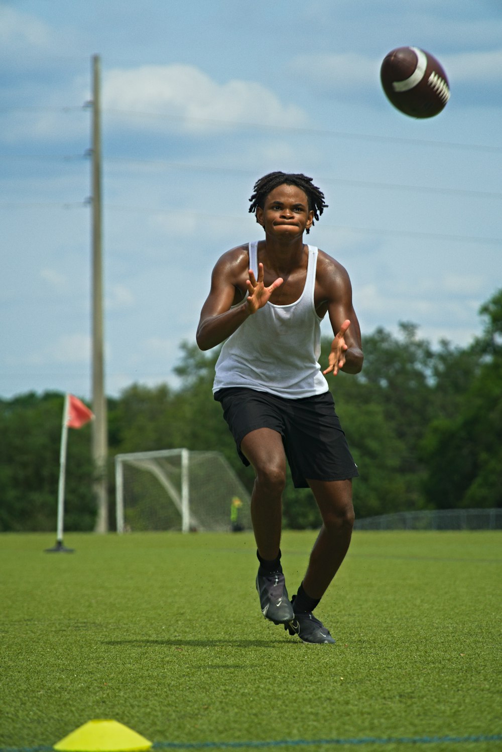 a man in a white tank top is playing frisbee