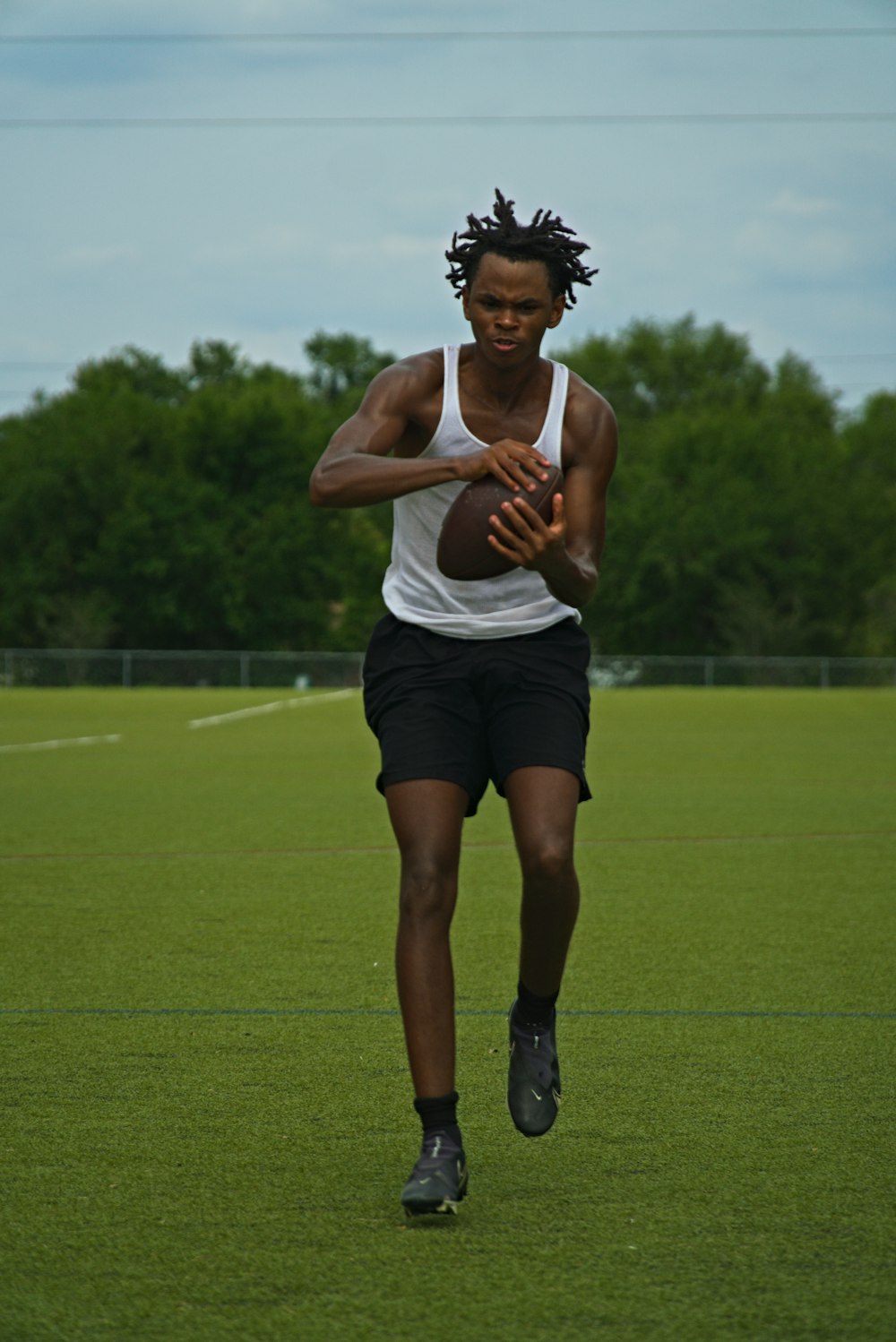 a man running with a football on a field