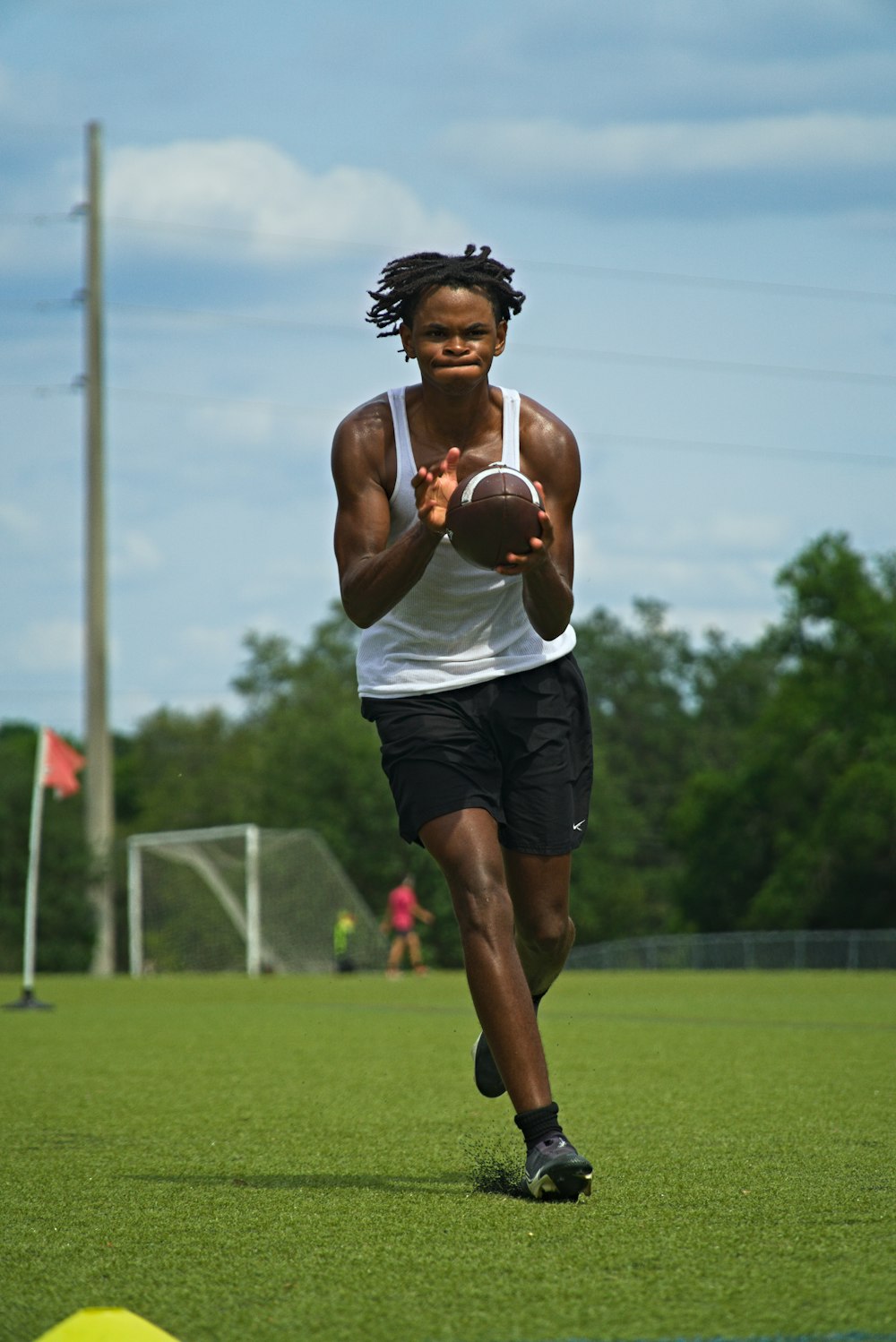 a man running with a football on a field