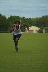 a man running across a field with a frisbee