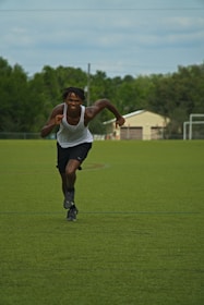a man running across a field with a frisbee