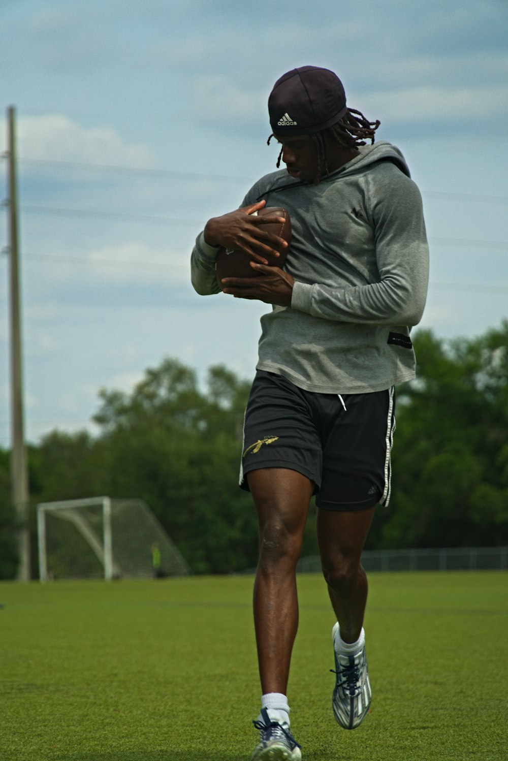 a man running on a soccer field holding a ball