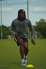 a man in grey shirt and black shorts playing a game of frisbee