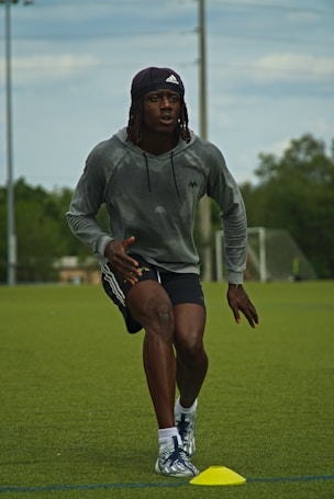 a man in grey shirt and black shorts playing a game of frisbee