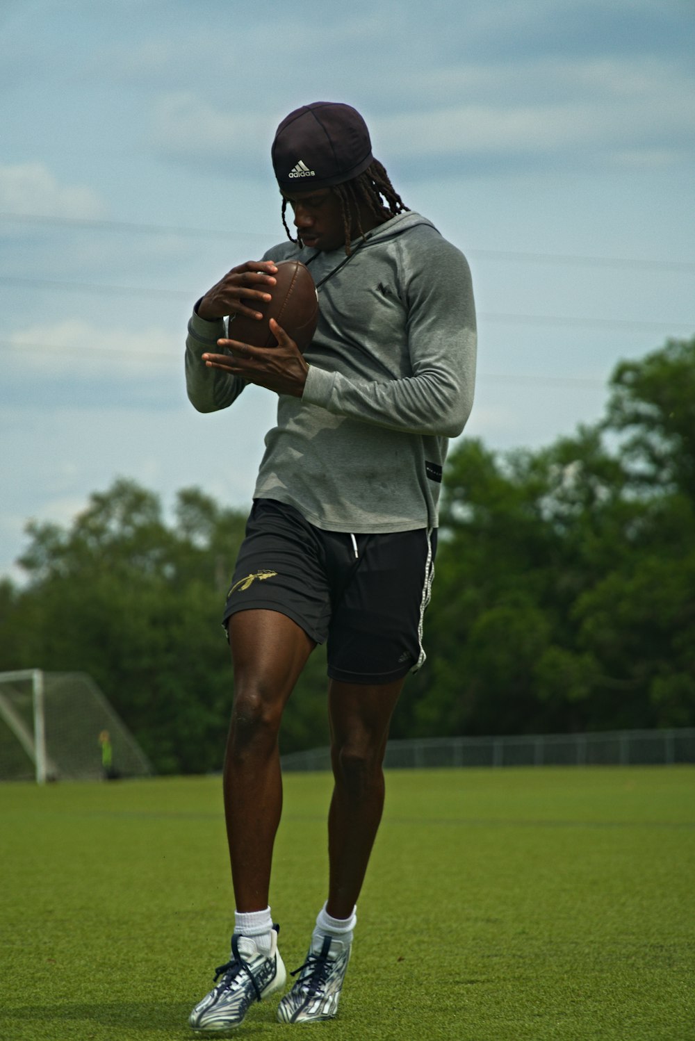 a man holding a football on top of a field